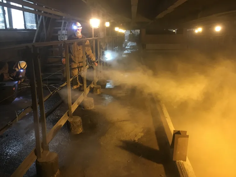 Dust suppression fog over a conveyor in a mining plant